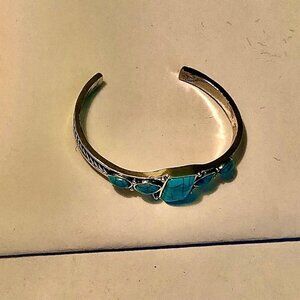 A simulated turquoise, silver bracelet with a large and 4 small turquoise stones